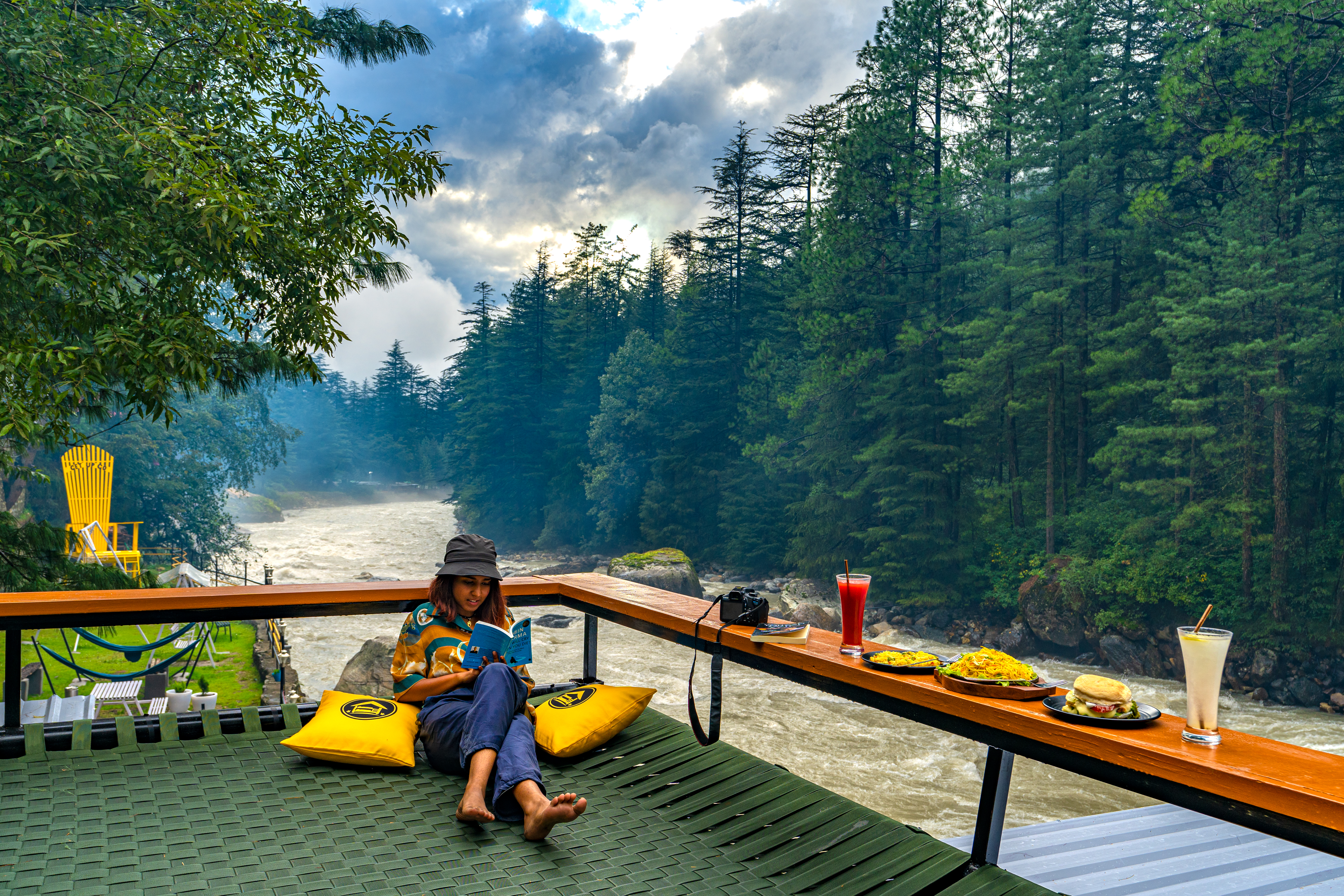 solo female traveller chilling at a hostel in Kasol by the riverside