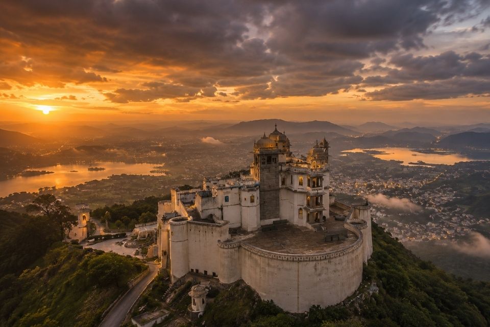 Aerial view of Sajjangarh Monsoon Palace at sunset overlooking Udaipur