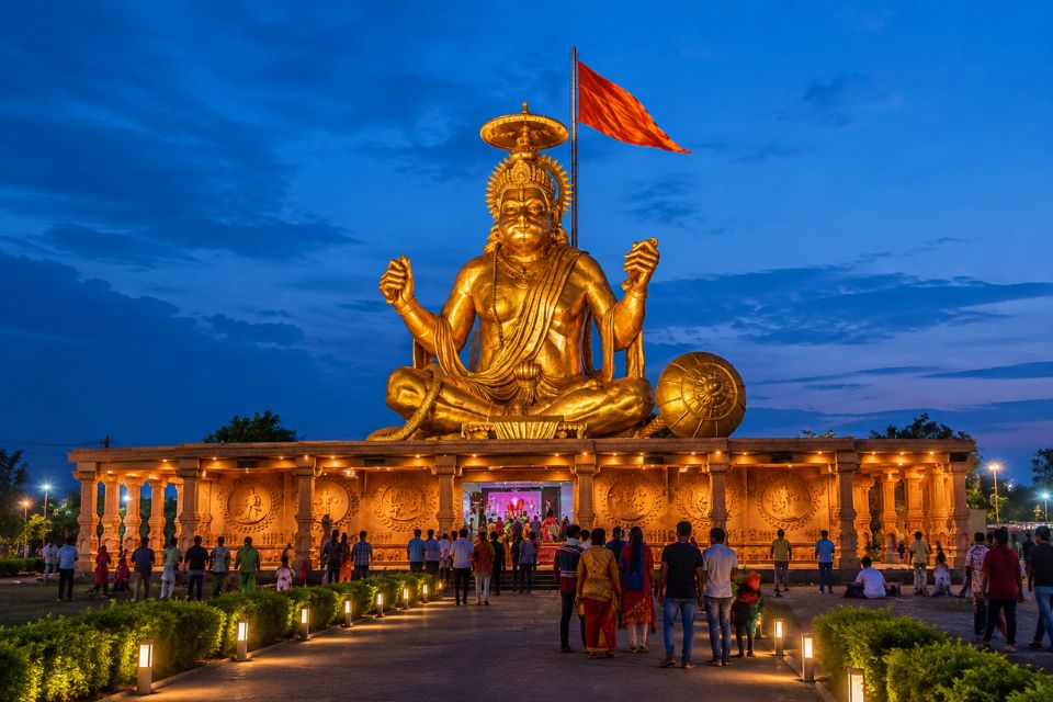 Golden Hanuman statue at Pitra Parvat lit up at dusk in Indore