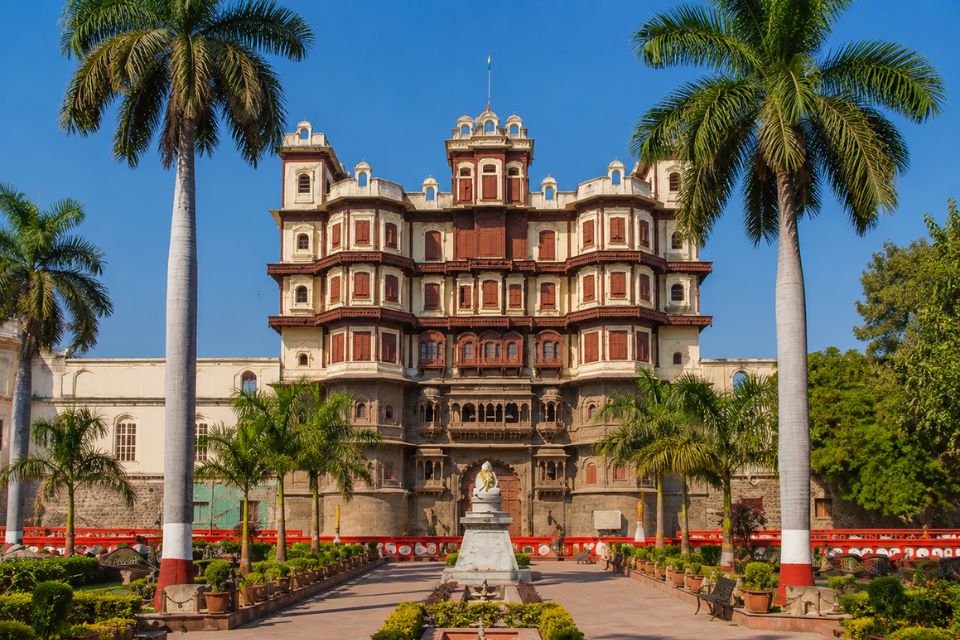 Rajwada Palace facade framed by palm trees, Indore