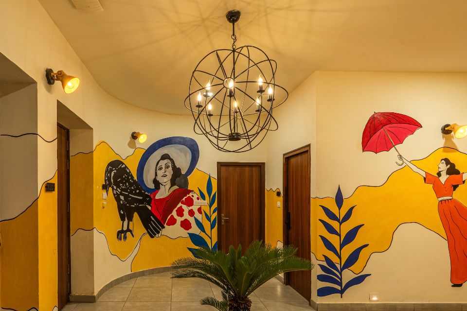Colourful murals and geometric patterns along a staircase inside The Hosteller BAM Udaipur, Artist House